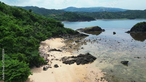 Aerial dolly of white sand, rocky beach resort and reef in the tropical island of the Philippines. Baras, Catanduanes photo