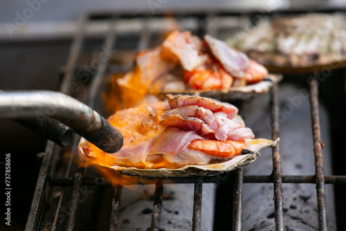 Cooking seafood at a food stall at the Tsukiji Outer Market in the city of Tokyo, Japan. photo