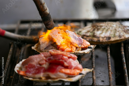 Cooking seafood at a food stall at the Tsukiji Outer Market in the city of Tokyo, Japan. photo