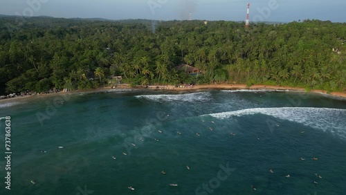 An ocean tropical lagoon by the jungle beach with surfing waves full of surfers and blue turquoise water photo