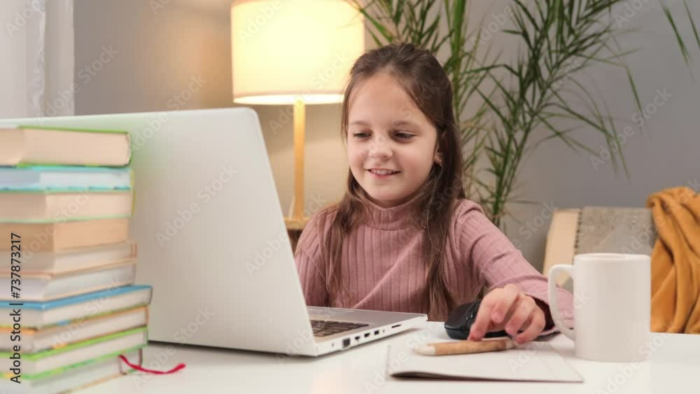 Young student studying online. Kid's virtual classroom on a computer. Homeschooling with technology. Caucasian little brown haired girl using laptop studying online at home Young student studying online. Kid's virtual classroom on a computer. Homeschooling with technology. Caucasian little brown haired girl using laptop studying online at home