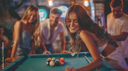 A group of happy friends playing billiards after work at a restaurant. photo