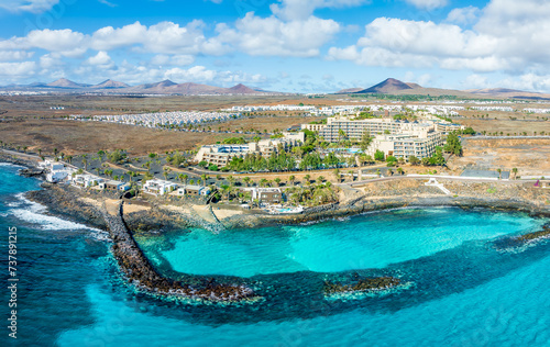 Obraz na płótnie Overlook the serene Playa El Ancla in Costa Teguise, Lanzarote, where crystal-clear waters and volcanic landscapes offer a picturesque retreat. w salonie
