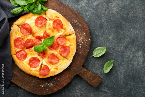 Pepperoni pizza. Traditional pepperoni pizza and cooking ingredients tomatoes basil on old concrete texture background table. Italian Traditional food. Top view. Mock up.