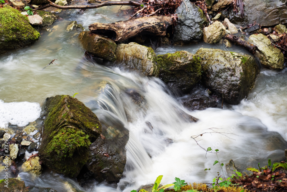 Mountain Waterfall, The water of a mountain river flows between boulders overgrown with moss. Nature background. Mountain Waterfall, The water of a mountain river flows between boulders overgrown with moss. Nature background.