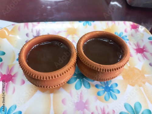 Green tea in clay cup, hot tea clay payali in winter,Desi mud cup of tea in winter Morning, 
Pair of mud cups of tea,Hot tea in winter,close up view of Indian two Mud tea cup in the color background  photo