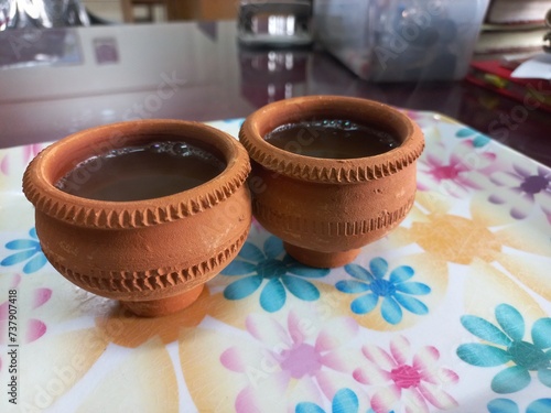 Green tea in clay cup, hot tea clay payali in winter,Desi mud cup of tea in winter Morning, 
Pair of mud cups of tea,Hot tea in winter,close up view of Indian two Mud tea cup in the color background  photo