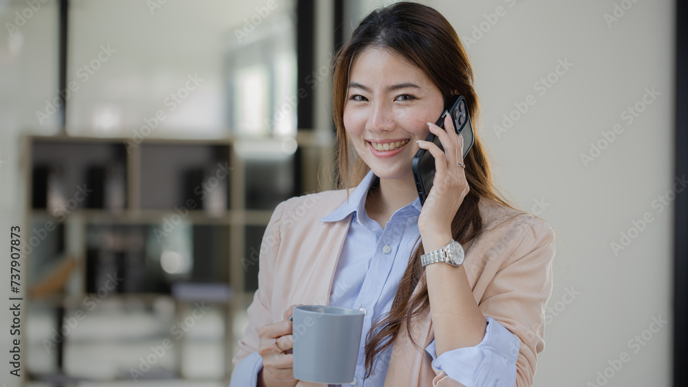Asian young businesswoman tacking a phone at office workplace. Asian young businesswoman tacking a phone at office workplace.