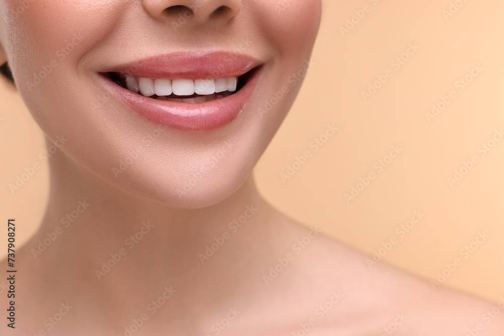Fototapeta premium Woman with beautiful lips smiling on beige background, closeup