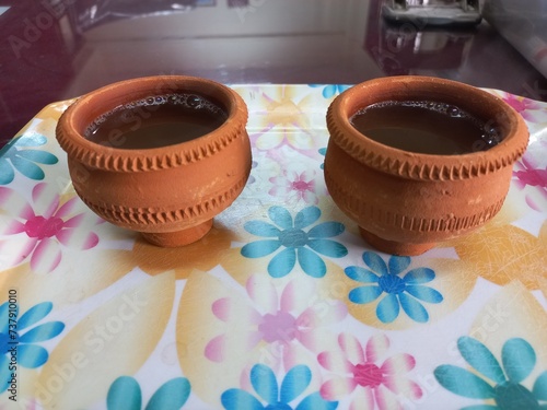 Green tea in clay cup, hot tea clay payali in winter,Desi mud cup of tea in winter Morning, 
Pair of mud cups of tea,Hot tea in winter,close up view of Indian two Mud tea cup in the color background  photo