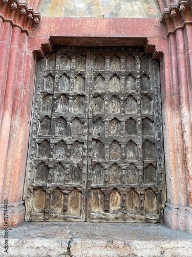 Antiguo portal de madera con arcos románicos en la Catedral de Verona, Italia. 