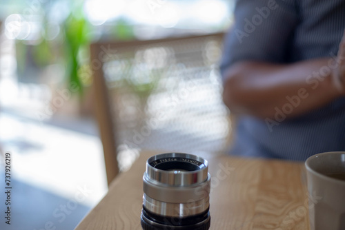 Fototapeta ,Close-up of hand holding camera,Close-up of camera,Close-up of hand holding camera lens,Old vintage camera placed on a blurred background