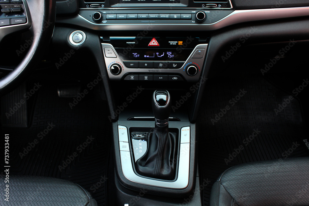 Automatic transmission gear knob. Modern leather interior of the new car. Gear stick with multimedia console. Button for shifting gears on car.