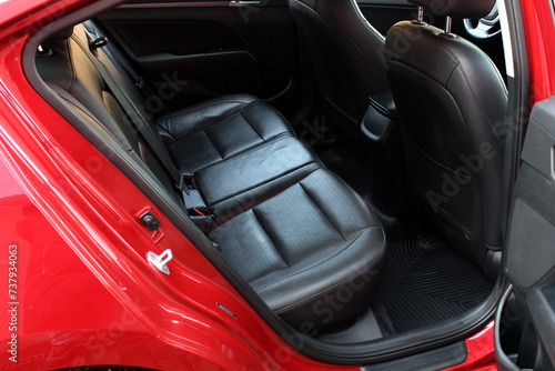 Back passenger seats in modern luxury car. Black leather rear seats. Three in the row. Frontal view, perforated black leather with stitching. Heated and ventilated seats.  © Best Auto Photo