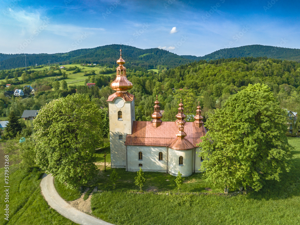 Lot nad Cerkwią Opieki Bogurodzicy w Łabowej wiosną. Widoki na cerkiew i okolicę.