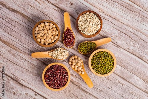 Fototapeta Naklejka Na Ścianę i Meble -  Mung beans, Red kidney beans, Chickpeas source and peeled barley in white cup on spoon wooden on wood background