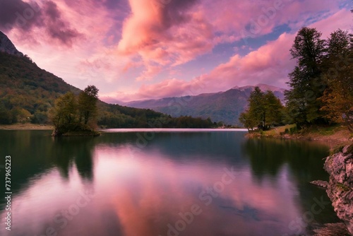 Beautiful pink cloudy sunset over a still mountain lake, dramatic colors photograph,