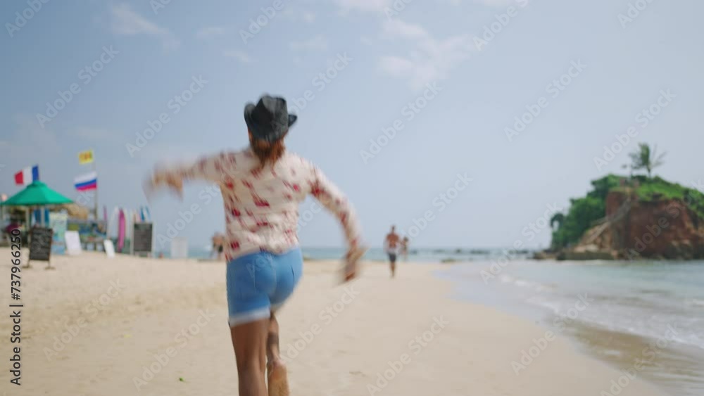 Energetic man in cowboy hat, flamboyant shirt invites to sunny beach getaway. Cheerful, diverse individual runs along shore, gesturing excitement, embodies freedom, vacation vibes. Energetic man in cowboy hat, flamboyant shirt invites to sunny beach getaway. Cheerful, diverse individual runs along shore, gesturing excitement, embodies freedom, vacation vibes.
