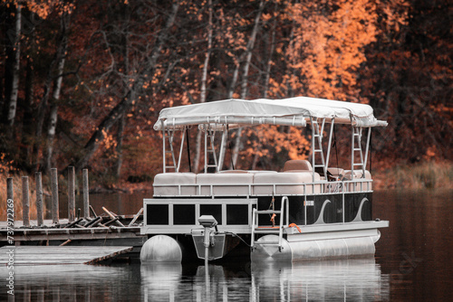 Photos The boat anchored by the pontoon floats on the lake against the background of tr