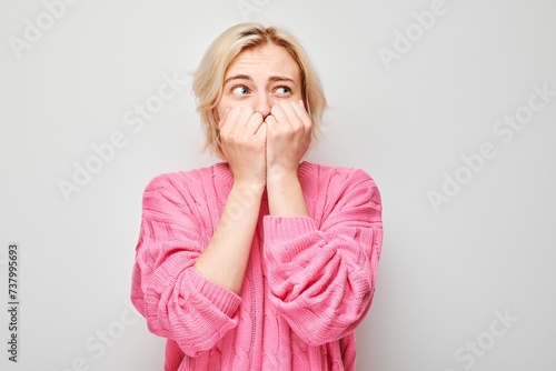 Portrait of girl with sad face worried, biting nails on white background. Nerves, stress, uncertainty concept.