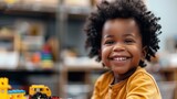 Portrait photo of african american curly child toddler playing in kindergarden smiling at camera with toothy smile