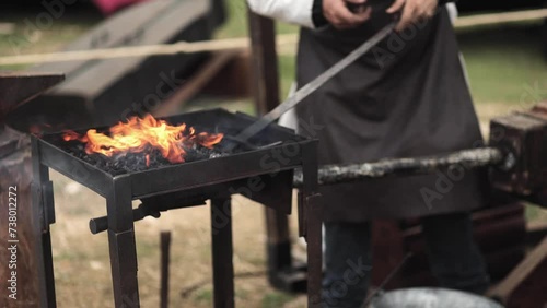 A blacksmith forges a sword. Middle-earth, medieval, craft, metal, metal roasting, fire, charcoal, festival, geek culture, cosplay.