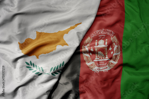 big waving national colorful flag of afghanistan and national flag of cyprus.