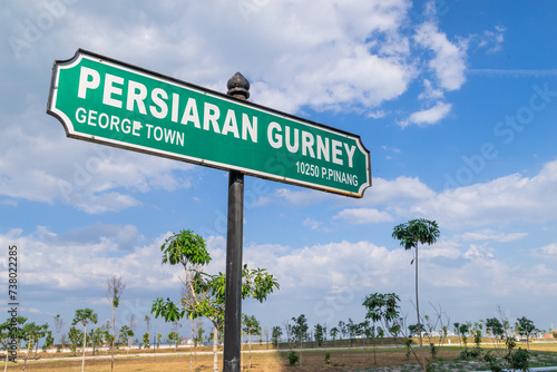 Gurney Drive street sign in George Town, Penang, Malaysia with newly constructed marina bay as background.