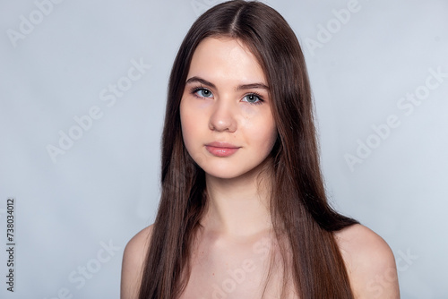 Beautiful Young Woman with Clean Fresh Skin touch own face .