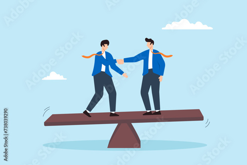 Two business people handshake and balancing on seesaw