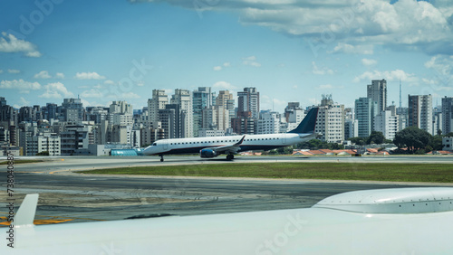 Commercial Airplane Prepares for Takeoff at Congonhas Airport on a Sunny Day with Sao Paulo, Brazil skyline in the background