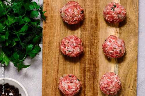 Raw beef meatballs on a cutting board .style hugge.top veiw