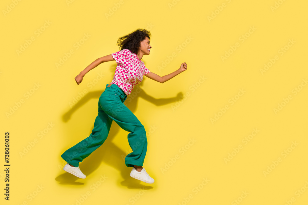 Full size profile photo of energetic carefree girl jump run fast empty space isolated on yellow color background