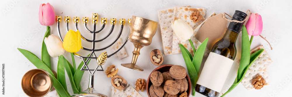 Passover celebration background. Traditional ritual Jewish bread matzah, red kosher wine, walnut, spring beautiful flowers. Jewish Easter Pesah spring holiday background copy space