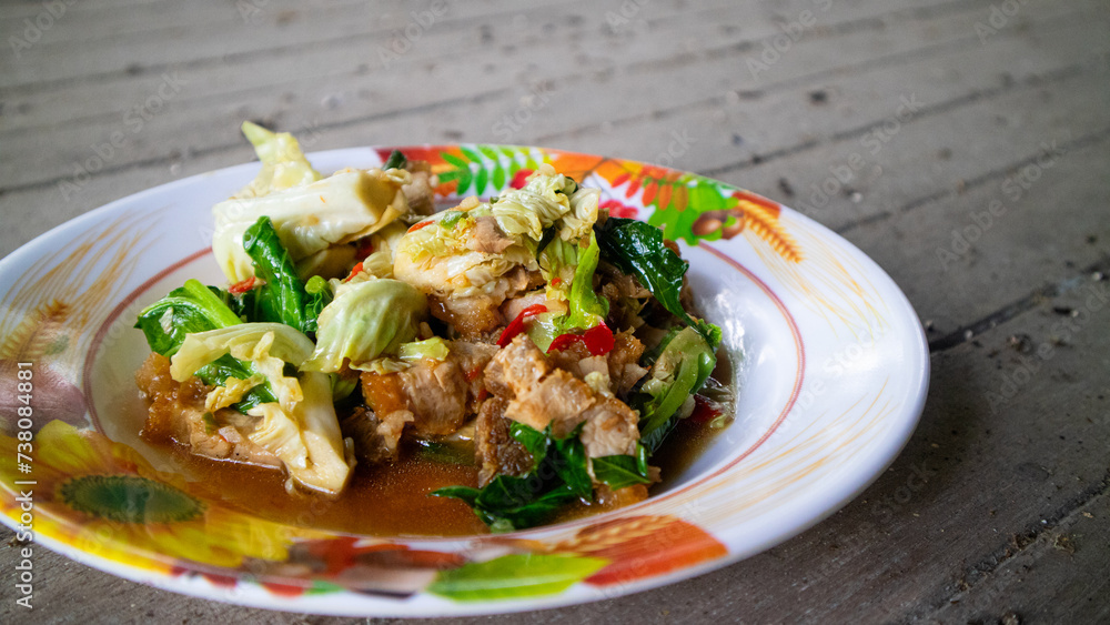 Stir fried kale with crispy pork in oyster sauce on white plate Stir fried kale with crispy pork in oyster sauce on white plate