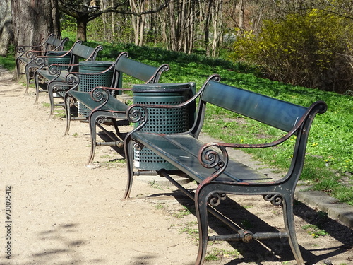 A row of green benches with litter bins in a park in Copenhagen