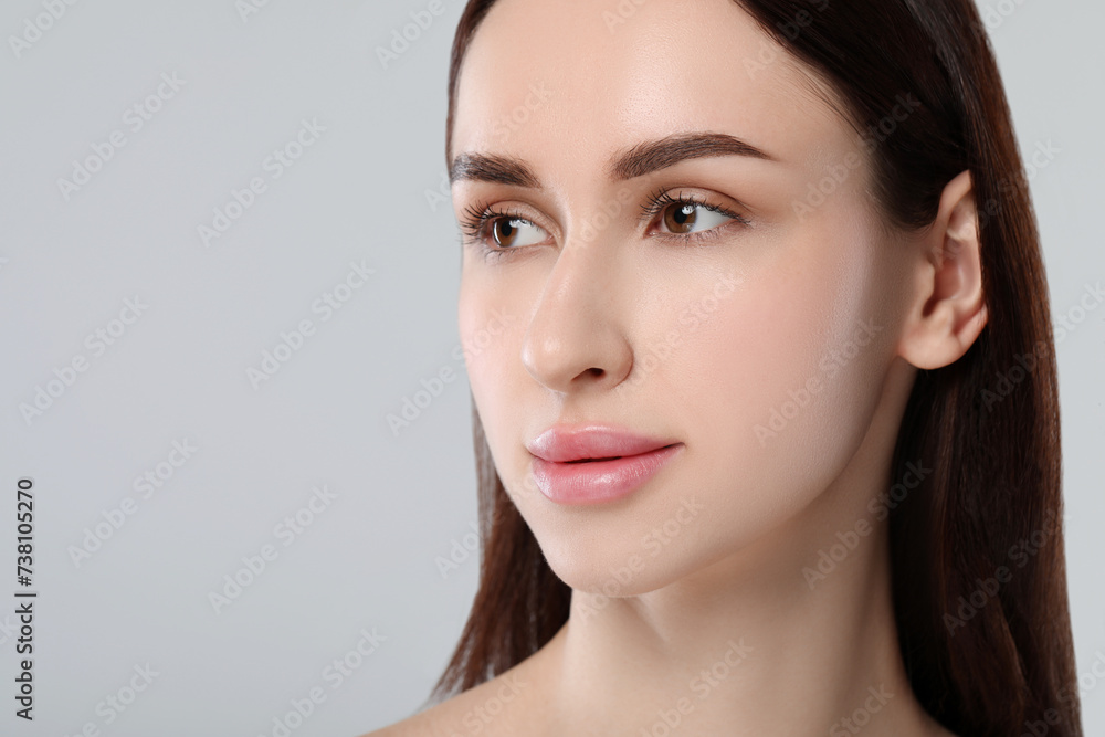 Fototapeta premium Portrait of beautiful young woman on light grey background. Space for text