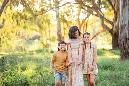 Portrait of mother and children walking together in Australian bush setting photo