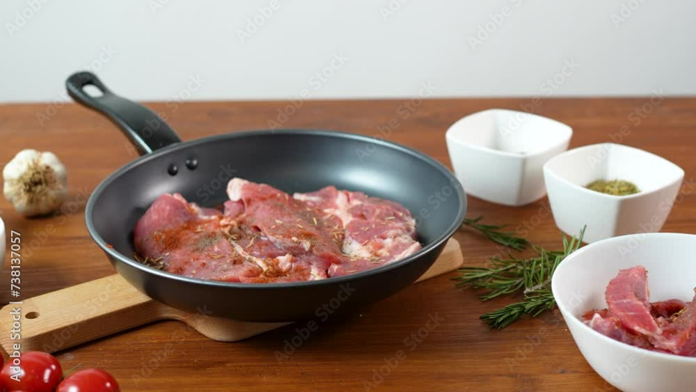 Raw meat in a pan with spices on a wooden table Raw meat in a pan with spices on a wooden table