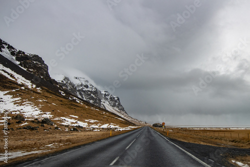 Driving in Iceland in Winter time, tourist trip around 1 Ring Road. Empty road stretching into the horizon with a snowy landscape. Iced pavel road, snow and glacier in self driving tour in Iceland. photo