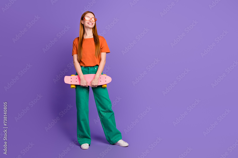 Photo of cheerful adorable girl wear trendy clothes hold skateboard enjoy summer season empty space ad isolated on purple color background Photo of cheerful adorable girl wear trendy clothes hold skateboard enjoy summer season empty space ad isolated on purple color background