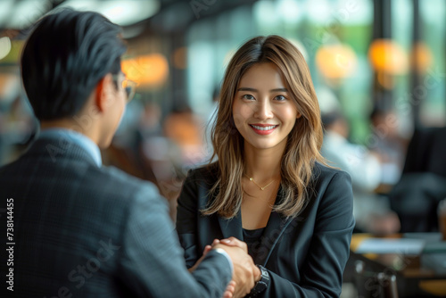 Asian business woman shaking hands with a client