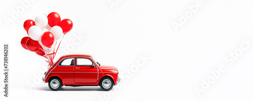 Red toy retro car with white and red balloons attached to it on a white background. Banner, card with empty space. Gift, congratulations