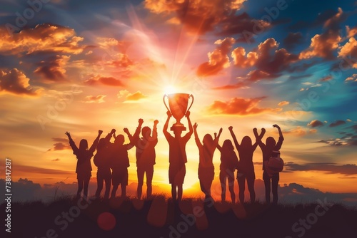 Energetic and inspiring image of a victorious team celebrating with a trophy at sunset