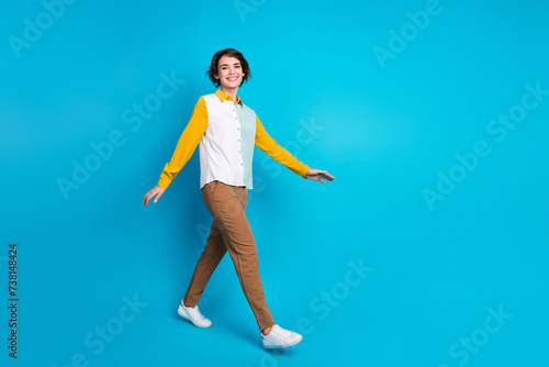 Full body length photo of positive secretary or assistant in office young woman in formalwear steps isolated on blue color background