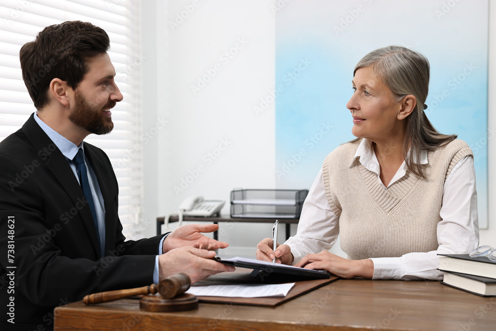 Senior woman signing document in lawyer's office Senior woman signing document in lawyer's office
