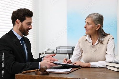 Wallpaper Mural Senior woman signing document in lawyer's office Torontodigital.ca