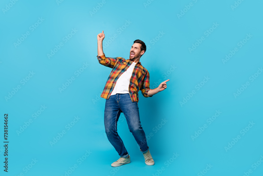 Full size photo of handsome young male dance celebrate discotheque dressed stylish checkered outfit isolated on blue color background Full size photo of handsome young male dance celebrate discotheque dressed stylish checkered outfit isolated on blue color background