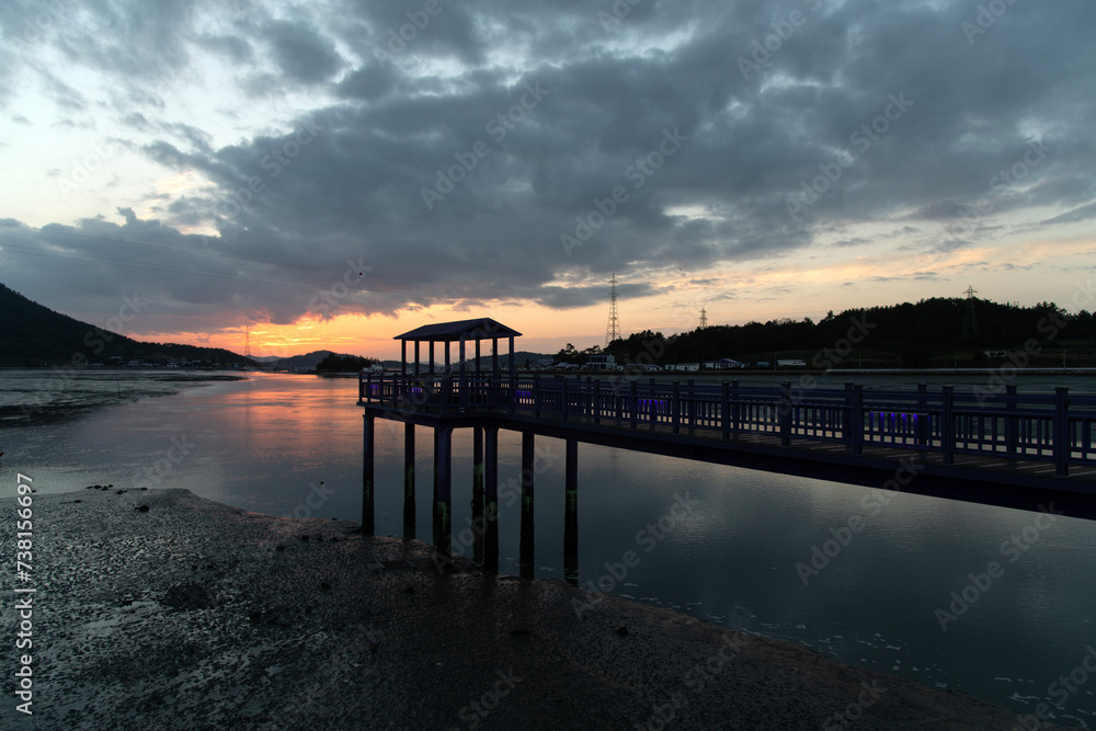 View of the sunset with wooden bridge at the seaside