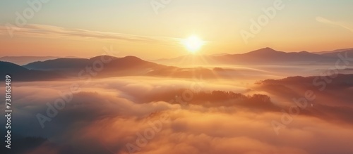Stunning sunrise scenery of foggy valley at mountain range in autumn.